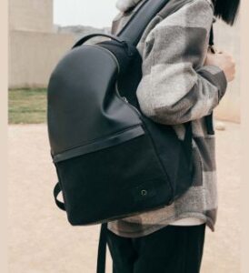 veganlyy one-concept young lady woman with backpack black vegan cruelty-free natural on her shoulder