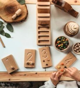 kid playing with little coach house numbercounting blocks - montessori learning resourse game looking from above