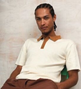 a young man wearing Komodo sand color frank organic cotton knit polo presented by veganlyy.com