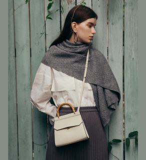 mini fir corn leather hand bag oat color worn by a young women with grey scarf around her shoulders and neck presented by veganlyy