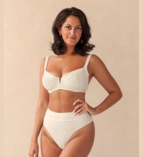 a woman wearing the veganlyy and via di gioia's the balconette bikini top and bottom in ivory white looking ahead