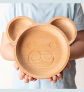 wills vegan store wooden kids plate presented by veganlyy a held by a kid