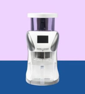 a white milky plant plus machine infront of us on rose and dark blue background presented by veganlyy